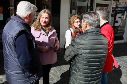 Cristina Ayala, candidata del PP a la Alcaldía de Burgos, charla con unos vecinos en la plaza de Santiago de Gamonal. TOMÁS ALONSO