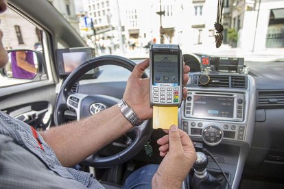 Un taxista ejecuta un cobro con tarjeta con el datáfono.-SANTI OTERO