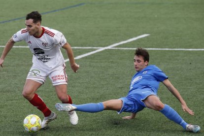 El lateral Tomás conduce el balón ante la entrada de un rival del Almazán en el partido de ayer en San Amaro. SANTI OTERO