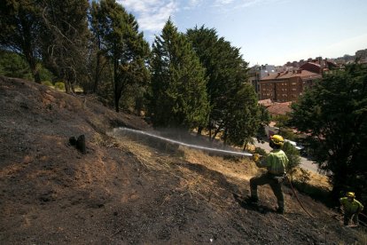 La cuadrilla de Medio Ambiente refrescó el terreno ayer por la mañana para evitar que el incendio volviera a prender avivado por el viento. FOTOS: TOMÁS ALONSO