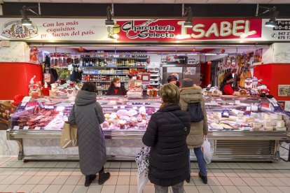Varios clientes esperan su turno en el puesto de Charcutería selecta Isabel, en el Mercado Norte. SANTI OTERO
