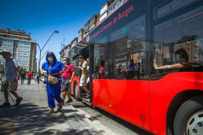 Varios pasajeros descienden del autobús municipal en la calle Santiago, en el barrio de Gamonal. TOMÁS ALONSO