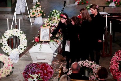 La familia de Ari Behn durante el funeral poniendo flores sobre el ataud.-EFE