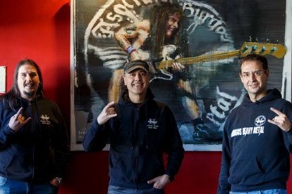 Gonzalo Navazo, Augusto Martínez e Íñigo Ortúñez, de la Asociación Heavy Metal Burgos, junto a un cuadro del pintor Sebas Velasco. SANTI OTERO