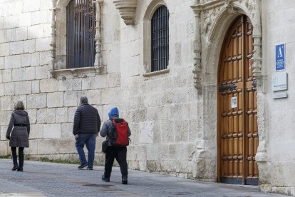 Varios viandantes pasan frente a la puerta del albergue municipal de peregrinos en la Casa del Cubo.