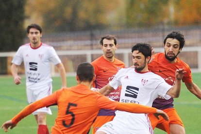 Los jugadores del Promesas Moyano y Óscar presionan al futbolista del Bupolsa David Fernández.-ISRAEL L. MURILLO