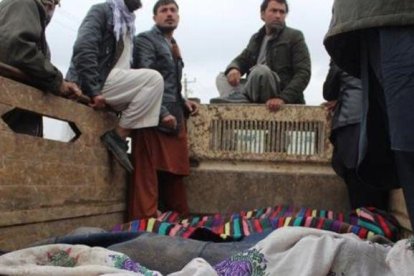 Un grupo de afganos trasladan los cuerpos de las 13 víctimas civiles asesinadas en Kunduz.-EFE