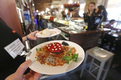 Un camarero muestra una tapa en un local de Burgos. SANTI OTERO