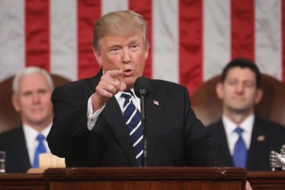 Trump, observado por el vicepresidente Pence (izquierda) y  por Paul Ryan, durante su discurso al Congreso.-JIM LO SCALZO