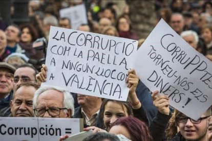 Asistentes a la manifestación contra la corrupción celebrada este domingo en Valencia portan carteles contra el PP y los casos que han afectado a esta comunidad.-MIGUEL LORENZO