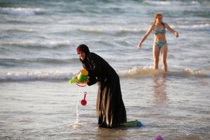 Una musulmana se baña con el hiyab en la playa en Tel Aviv.-BAZ RATNER / REUTERS