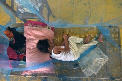 Pacientes que sufren de dengue descansan en un gimnasio cubiertos con mosquiteros en la ciudad de Maasin, Filipinas.-LEO SOLINAP (EFE/EPA)
