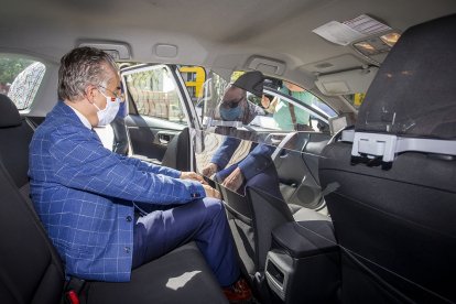 El delegado de la Junta, Roberto Saiz, inspecciona una de las mamparas que entregó ayer tras ser instalada en un taxi. SANTI OTERO