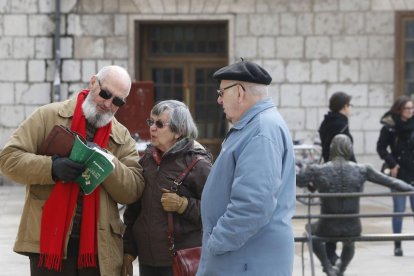 Un turista en la plaza de San Fernando consulta en un mapa con unos ciudadanos un lugar a donde acudir.-RAÚL OCHOA