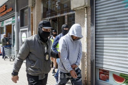 Un agente lleva a uno de los detenidos tras el registro de la vivienda. SANTI OTERO