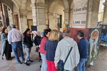 Un grupo de personas observa los cuadros pintados por enfermos y socios de la entidad. ECB