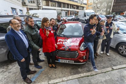 De la Rosa con parte de su candidatura junto al vehículo eléctrico que usa esta campaña electoral.