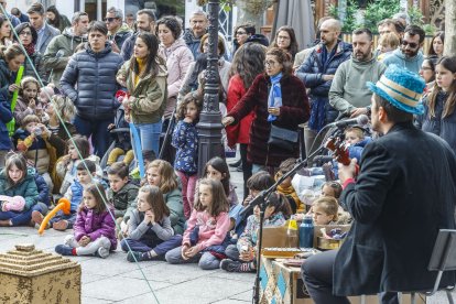 Varias personas disfrutan de un espectáculo de calle.