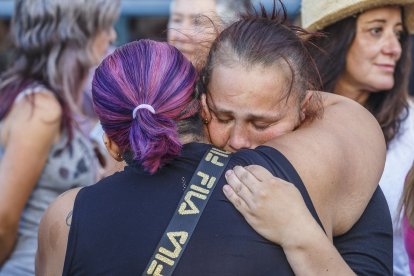 La hermana de la joven se abraza con una mujer en la concentración.