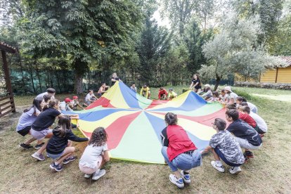 Los niños del campamento urbano de Fuentes Blancas se conocen gracias al juego del paracaídas.