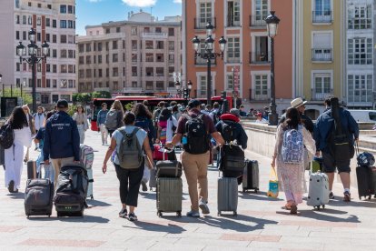 Un grupo de turistas con maletas cruza por el puente Santa María de la capital burgalesa.