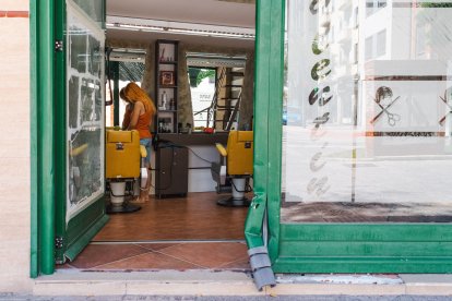 Regina González, en el interior de la peluquería que regenta, en cuya entrada permanecen aún las pruebas del suceso.