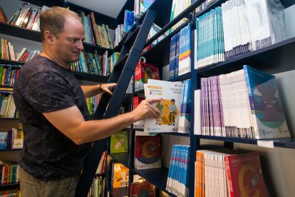 Víctor Adot coloca un libro en la librería La Llave.