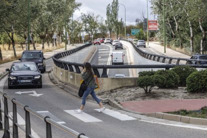 Una mujer cruza el paso de peatones que baja desde el Centro Comercial El Mirador hasta la avenida Cantabria y esas vallas dificultan que sea vista con más antelación por los vehículos.