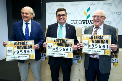 Presidente y vicepresidente del Banco de Alimentos, Julián Martínez Pantoja y Miguel Ángel López, flanquean al jefe de la Zona Centro de Cajaviva Caja Rural, Javier García Bueno, para mostrar el número de lotería solidaria.