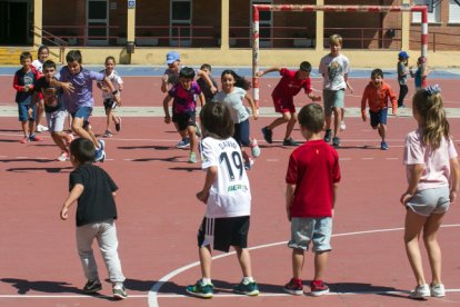 Varios niños y niñas juegan en el patio de un colegio.