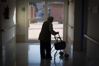 Una anciana pasea en una residencia.