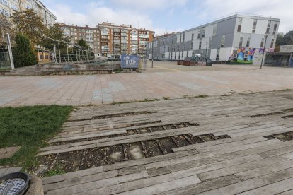 Pavimento del parque Félix Rodríguez de la Fuente deteriorado y vallas de obra, al fondo.