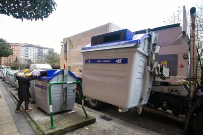 Una mujer recicla papel y cartón en una isla de contenedores de la capital burgalesa.