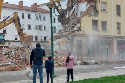 Un numeroso grupo de vecinos seguía el derribo desde la acera de enfrente.