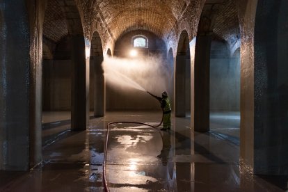 Un operario de Aguas de Burgos utiliza agua a presión uno de los depósitos del cerro de San Miguel.