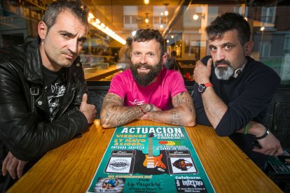 Sergio de la Fuente (centro), flanqueado por Raúl y Pedro, componentes de Triaje, con el cartel del concierto solidario que se celebra este viernes en La Guarida.