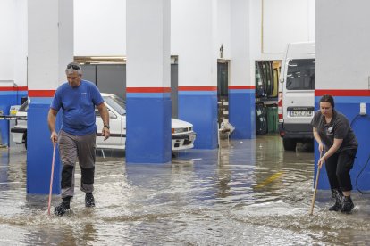 Imagen de empleados de un taller achicando agua.