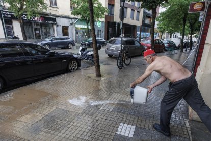 Un hombre achica agua tras la tormenta.