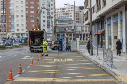 Los operarios de la empresa de señalización, pintando esta mañana la zona de carga y descarga de la parada de autobús de la avenida de la Paz.