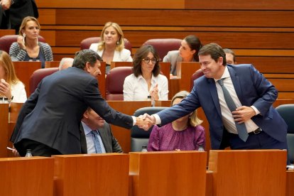 El presidente de la Junta, Alfonso Fernández Mañueco, felicita al consejero de Economía y Hacienda, Carlos Fernández Carriedo, tras finalizar la votación sobre la aprobación del techo de gasto financiero durante la segunda jornada del pleno de las Cortes de Castilla y León.