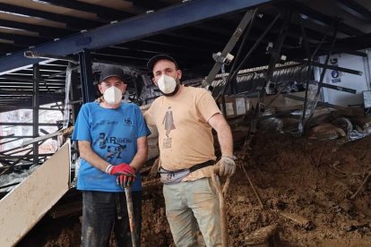 Los burgaleses César y Samuel Calvo llevan desde el martes vaciando el barro de una empresa de Chiva en Valencia.