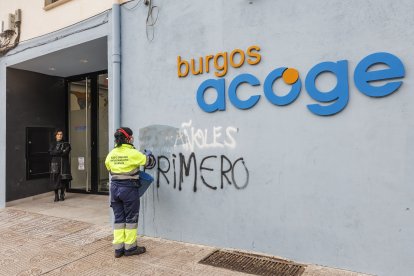 Una operaria de limpieza borra una pintada xenófoba en Burgos Acoge.