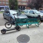 Bicis y patinete amarrados a un banco en la avenida de la Paz de Burgos.