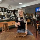 Dana posa junto a la mesa de madera de roble que ha fabricado su padre