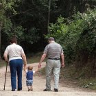 Un niño camina de la mano de dos personas mayores. TOMÁS ALONSO