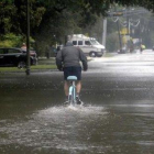 Un hombre circula con una bicicleta por una calle anegada en Beaumont (Tejas).-AP