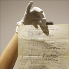 Un empleado de Sotheby's muestra el manuscrito de 'A hard rain's a-gonna fall' de Bob Dylan.-AP / FRANK AUGSTEIN