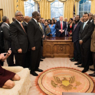 Kellyanne Conway, de rodillas y con zapatos, consulta su móvil mientras Trump y sus invitados posan para la foto oficial-AFP