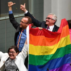 Tres diputados agitan la bandera arcoiris tras la aprobación de la ley.-MICK TSIKAS