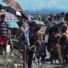 Un refugiado rohinyá lleva a cuestas a un anciano en Bangladés, cerca de la frontera con Birmania-AFP